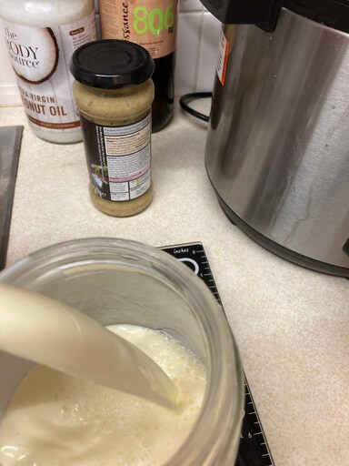 pouring milk into jar with kefir (46K).